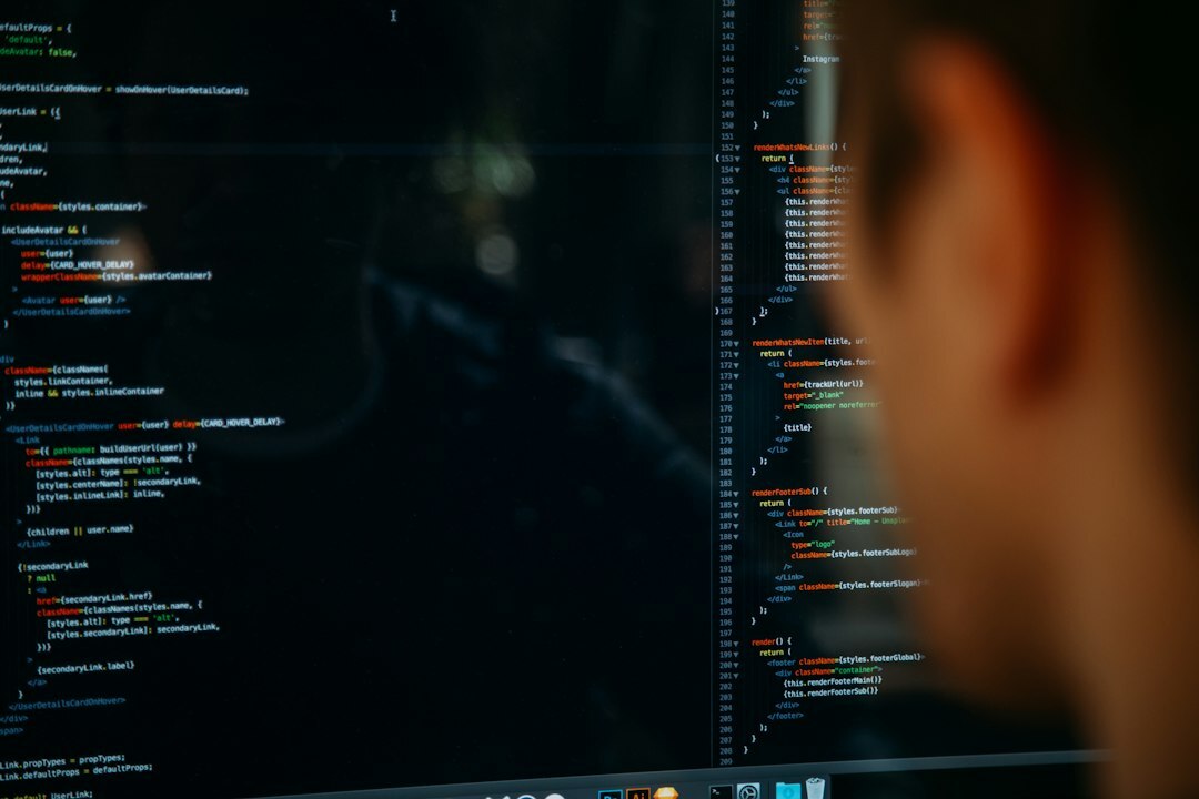 Two software developers reviewing code together on a laptop